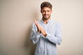 Young handsome man with beard wearing striped shirt standing over white background clapping and applauding happy and joyful, Royalty Free Stock Photo