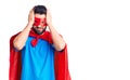 Young handsome man with beard wearing super hero costume suffering from headache desperate and stressed because pain and migraine