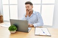 Young handsome man with beard working at the office using computer laptop bored yawning tired covering mouth with hand Royalty Free Stock Photo