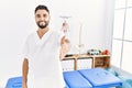 Young handsome man with beard working at pain recovery clinic smiling friendly offering handshake as greeting and welcoming Royalty Free Stock Photo