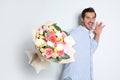 Young handsome man with beautiful flower bouquet on light Royalty Free Stock Photo