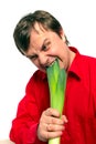 Young handsome man is biting a green leek. Royalty Free Stock Photo