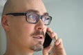 Young handsome man in black glasses is talking on the phone and smiling. Closeup portrait of a man. Manager, office worker, Royalty Free Stock Photo