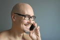 Young handsome man in black glasses is talking on the phone, smiling. Closeup portrait of a man. Manager, office worker, talking Royalty Free Stock Photo