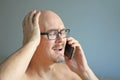 Young handsome man in black glasses is talking on the phone and is surprised. Big problems, bad news. Closeup portrait of a man.