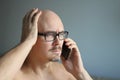 Young handsome man in black glasses is talking on the phone and is surprised. Big problems, bad news. Closeup portrait of a man.