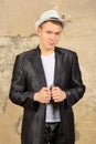 Young handsome man in black jacket and white hat Royalty Free Stock Photo