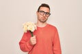 Young handsome man with blue eyes holding bouquet of flowers over white background with a confident expression on smart face Royalty Free Stock Photo