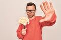 Young handsome man with blue eyes holding bouquet of flowers over white background with open hand doing stop sign with serious and Royalty Free Stock Photo