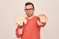 Young handsome man with blue eyes holding bouquet of flowers over white background pointing with finger to the camera and to you, Royalty Free Stock Photo