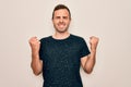 Young handsome man with blue eyes wearing casual t-shirt standing over white background very happy and excited doing winner Royalty Free Stock Photo
