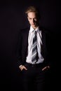 Young handsome man in a business suit and a white shirt and tie in formal style in the Studio on a black background Royalty Free Stock Photo