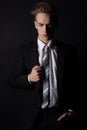 Young handsome man in a business suit and a white shirt and tie in formal style in the Studio on a black background Royalty Free Stock Photo
