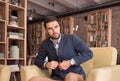 Young handsome man buttoning suit indoors cafe Royalty Free Stock Photo