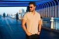 Young handsome man in classik polo t-shirt on the street. Handsome confident stylish hipster model posing outside. Sexy Royalty Free Stock Photo