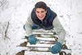 Young handsome man climbing upwards wooden ladder