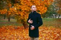 Young handsome man in coat. Fashionable well dressed man posing in stylish coat. Confident and focused boy outdoor at autumn. Royalty Free Stock Photo
