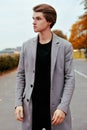 Young handsome man in coat. Portrait of fashionable well dressed man posing in grey stylish coat. Confident and focused boy Royalty Free Stock Photo