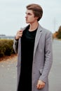 Young handsome man in coat. Portrait of fashionable well dressed man posing in grey stylish coat. Confident and focused boy Royalty Free Stock Photo