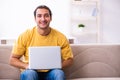 Young handsome man with computer at home Royalty Free Stock Photo
