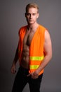 Young handsome man construction worker shirtless against gray ba Royalty Free Stock Photo