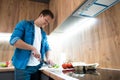 Young handsome man cooking in the kitchen Royalty Free Stock Photo