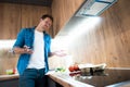 Young handsome man cooking in the kitchen with knife in his hand Royalty Free Stock Photo