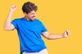 Young handsome man with curly hair wearing casual clothes dancing happy and cheerful, smiling moving casual and confident Royalty Free Stock Photo