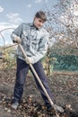 Young handsome man digs the ground under the landing