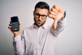 Young handsome man doing payment using dataphone over isolated white background with angry face, negative sign showing dislike Royalty Free Stock Photo