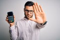 Young handsome man doing payment using dataphone over isolated white background with open hand doing stop sign with serious and Royalty Free Stock Photo