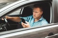 Young handsome man drives unsafely checking his smartphone on the run