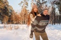 A young handsome man of European appearance and a young Asian girl in a park on the nature in winter. A Royalty Free Stock Photo