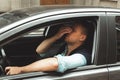 Young handsome man feels upset sitting in his car