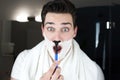 Young handsome man with foam on his face having fun while shaving in bathroom everyday routine Royalty Free Stock Photo