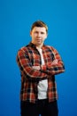 Young handsome man with happy face smiling with crossed arms looking at the camera over blue studio background. Positive person Royalty Free Stock Photo