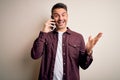 Young handsome man having conversation talking on the smartphone over white background very happy and excited, winner expression Royalty Free Stock Photo