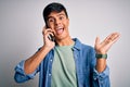 Young handsome man having conversation talking on the smartphone over white background very happy and excited, winner expression Royalty Free Stock Photo