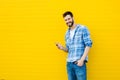 Young handsome man with headphones on yellow wall Royalty Free Stock Photo