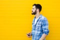 Young handsome man with headphones on yellow wall Royalty Free Stock Photo