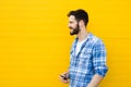 Young handsome man with headphones on yellow wall Royalty Free Stock Photo