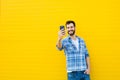 Young handsome man with headphones on yellow wall Royalty Free Stock Photo