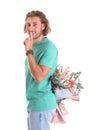 Young handsome man hiding beautiful flower bouquet behind his back