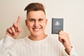 Young handsome man holding Australia Australian passport over isolated white background surprised with an idea or question