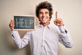 Young handsome man holding blackboard with help message over isolated white background surprised with an idea or question pointing Royalty Free Stock Photo