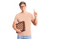 Young handsome man holding chess surprised with an idea or question pointing finger with happy face, number one Royalty Free Stock Photo