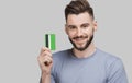 Young handsome man holding credit card isolated on white background. Online shopping, ecommerce, internet banking concept Royalty Free Stock Photo