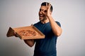 Young handsome man holding delivery box with delicious Italian pizza over white background with happy face smiling doing ok sign Royalty Free Stock Photo