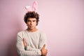 Young handsome man holding easter rabbit ears standing over isolated pink background skeptic and nervous, disapproving expression Royalty Free Stock Photo