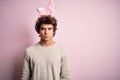 Young handsome man holding easter rabbit ears standing over isolated pink background skeptic and nervous, frowning upset because Royalty Free Stock Photo